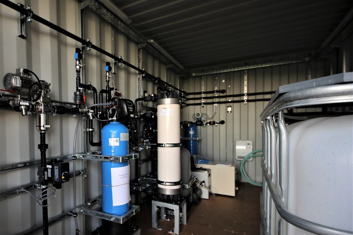 Innenansicht des mobilen PHYSICS-FOR-FOOD-Demonstrators mit Filtereinheiten, Behältern und angeschlossenen Leitungen zur Wasseraufbereitung.