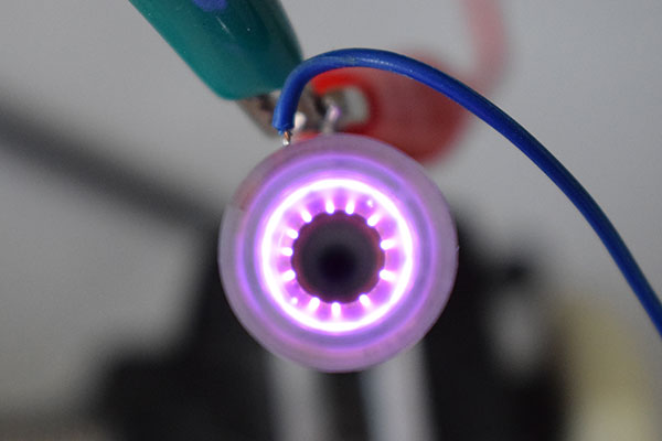 Leuchtendes Plasma in einer zylindrischen Hochspannungselektrode mit ringförmiger Emission.