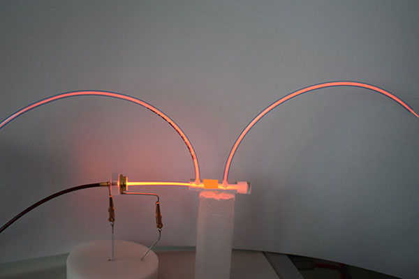 Hochspannungselektrode in einem transparenten Schlauch mit sichtbar leuchtender Plasmaentladung.