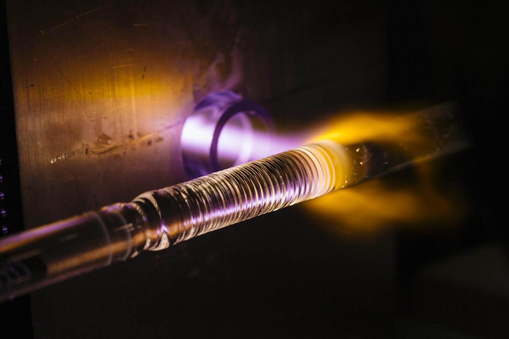 Mikrowellenplasma um eine rotierende Quarzglasvorform, das für die Herstellung optischer Hochleistungsfasern genutzt wird.