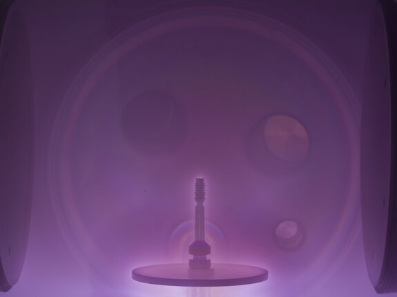 Zahnimplantat in einer Vakuumkammer während eines plasmabasierten Oberflächenveredelungsprozesses.