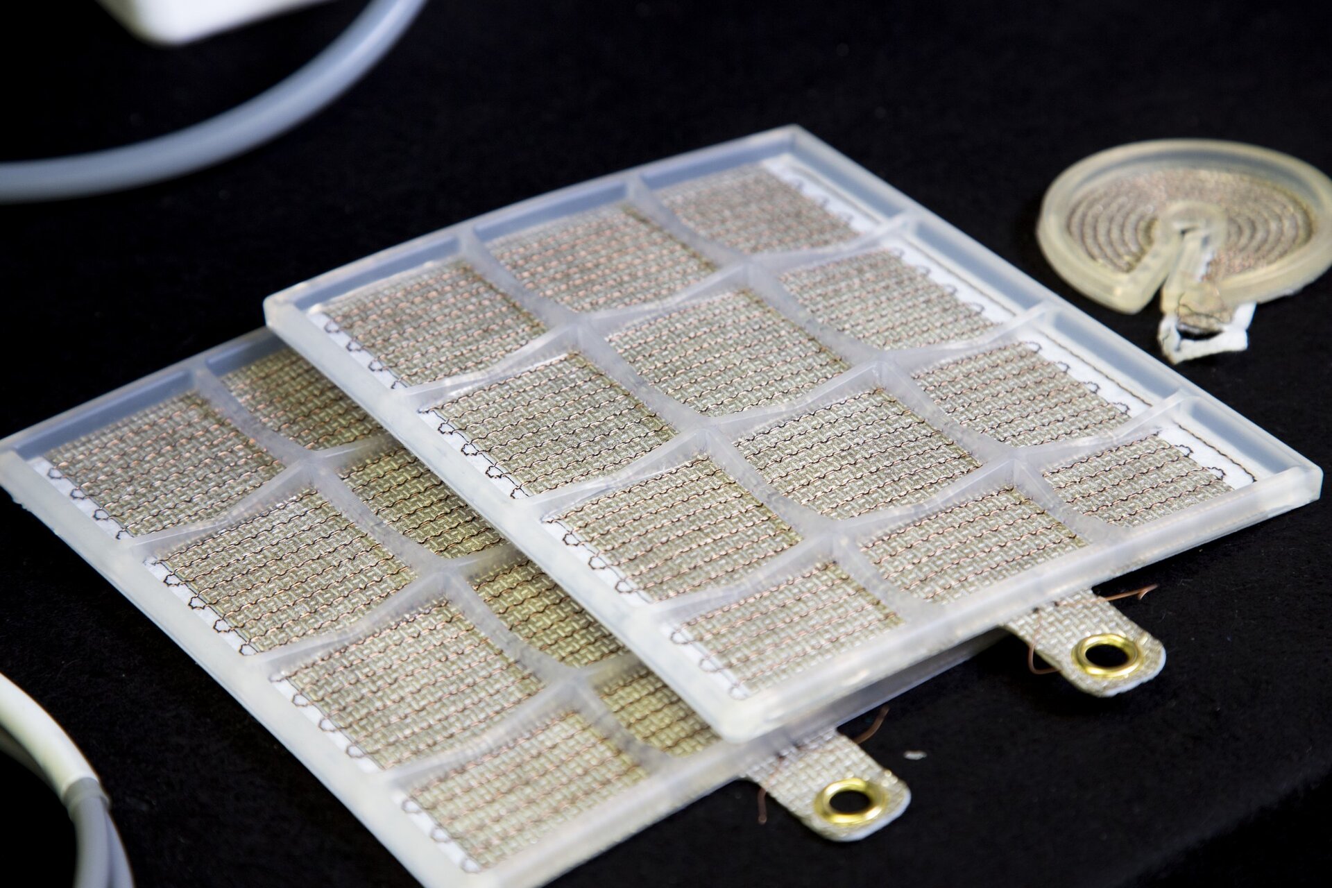 Zwei flexible, gitterförmige Elektrodenträger eines Plasma-Pflasters in Nahaufnahme.