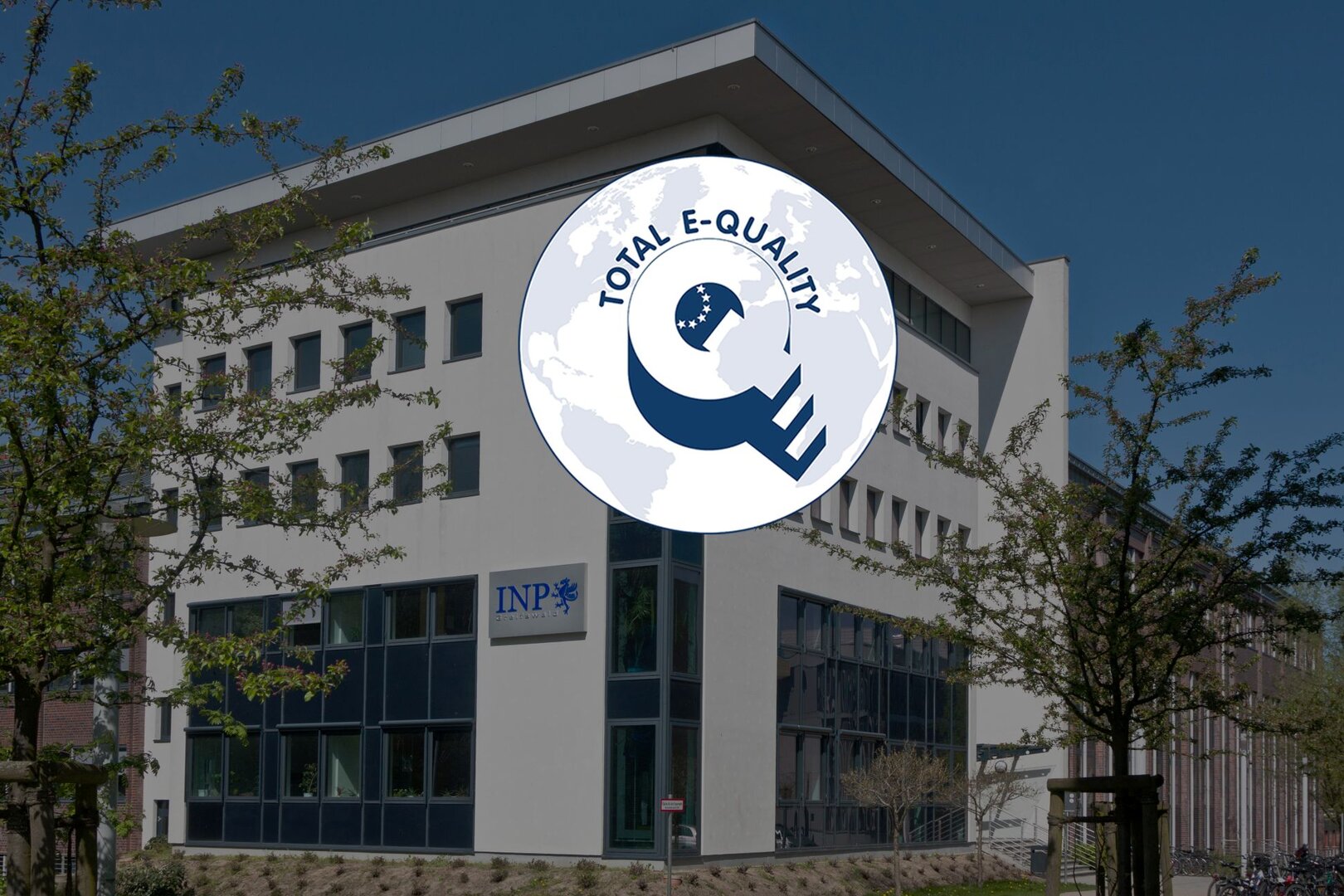 INP-Gebäude in Greifswald mit eingeblendetem TOTAL E-QUALITY-Logo als Symbol für die fünfte Auszeichnung des Instituts.